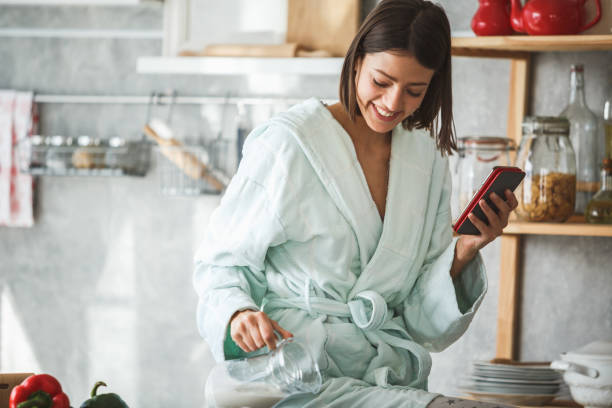 istock Happy woman preparing breakfast and using smart phone at home 1144347812