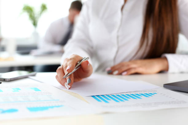 istock Female arm in suit hold silver pen and pad 1144348169