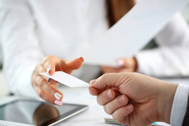 istock Female arm in suit give blank calling card to visitor 1144348202