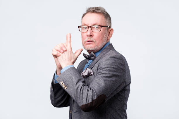 istock Senior man pretending he is holding gun 1144349007