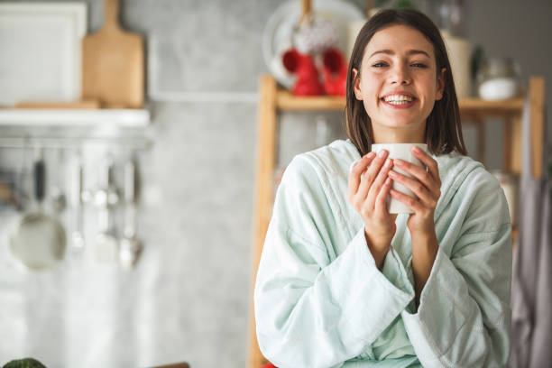 istock Cheerful woman drinking morning coffee at home 1144349231