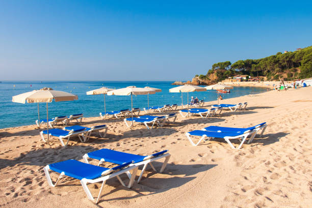 istock Cala de Fenals beach in Lloret de Mar, Costa Brava. Sandy resort beach in Spain with deck chairs and sun umbrella 1144349517