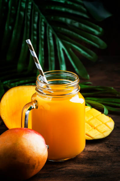 istock Mango smoothie jar with fresh fruit on rustic wooden background, copy space, summer drink concept 1144350231