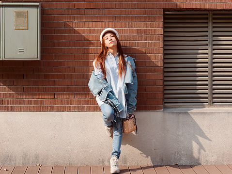Street Photography Of A Cute Chinese Young Woman In Jeans And White Hat  With Brick Wall Background Female Portrait Stock Photo - Download Image Now  - iStock