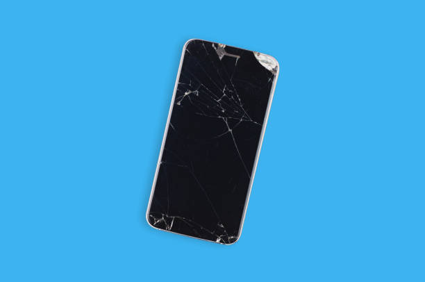 istock Black crashed smartphone with broken screen and body on blue table in service. Top view. Repair concept 1144350971
