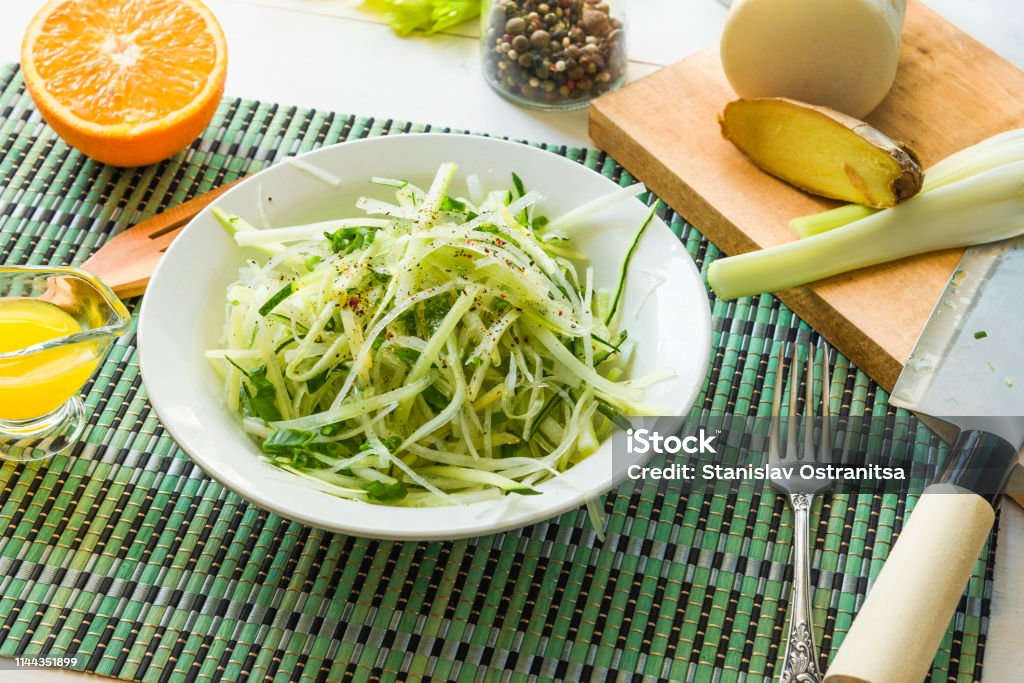 Bowl of healthy vegetarian salad of raw vegetables - daikon radish, celery, cucumber and spring onions - organic cuisine. Close-up. Bowl Stock Photo