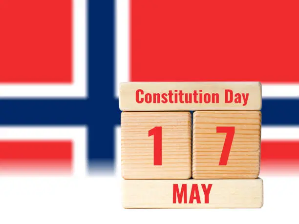 17 may, norwegian constitution day, wooden toy blocks with blurred flag background