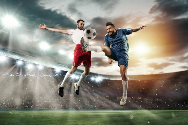 Free Stock Photo of Two footballers are fighting for the ball on the  football field