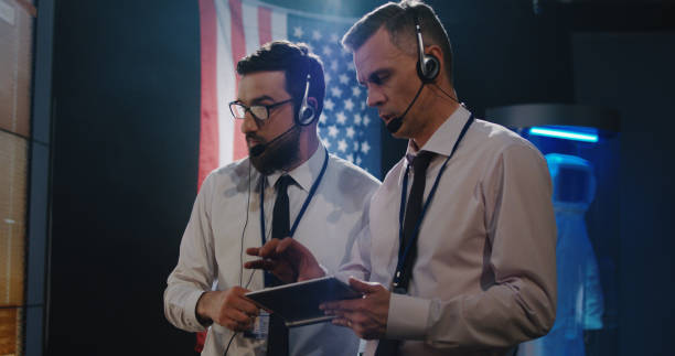 two technicians watching screen in control room - ground crew audio imagens e fotografias de stock