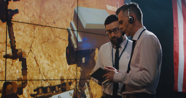 two technicians watching screen in control room - ground crew audio imagens e fotografias de stock