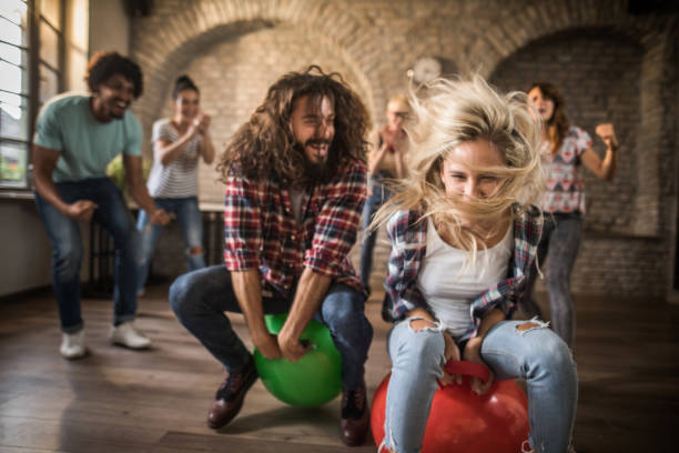 istock Joyful freelance workers having fun in space hopper challenge at casual office. 1144353763