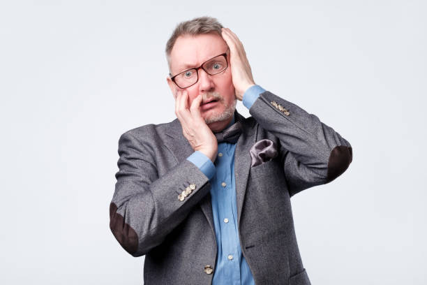 istock man holding hand on his head having forgetful look 1144355290
