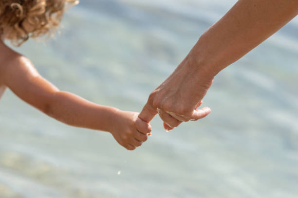 istock Mother holding hands of her daughter 1144355520