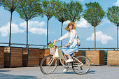 Woman cycling in blue dress on white bicycle.