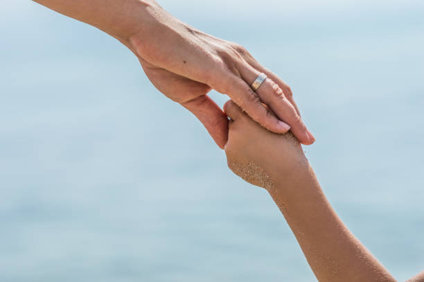 istock Mother holding hands of her daughter 1144356392