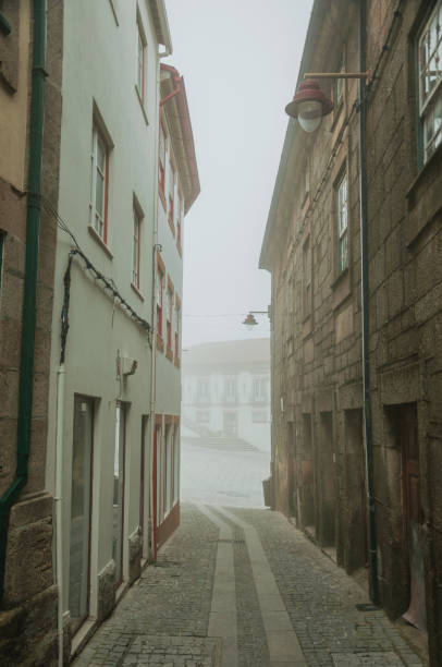 vecchie case e vicolo deserto nella nebbia del mattino - street light fog morning country road foto e immagini stock
