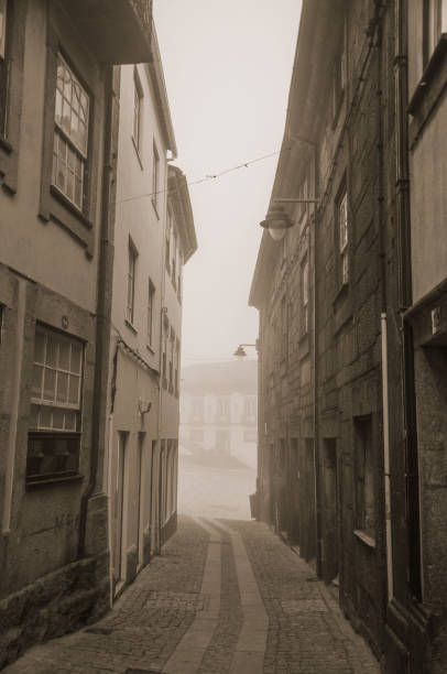 vecchie case e vicolo deserto nella nebbia del mattino - street light fog morning country road foto e immagini stock