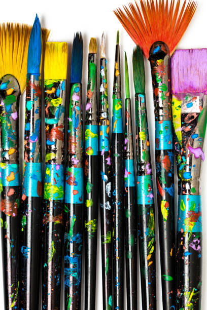 istock Row of paint stained paintbrushes isolated on white background. Artistic background 1144356771