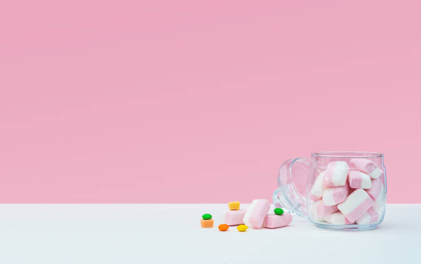 istock Marshmallow with dragee next to the glass open transparent jar and in it 1144357580