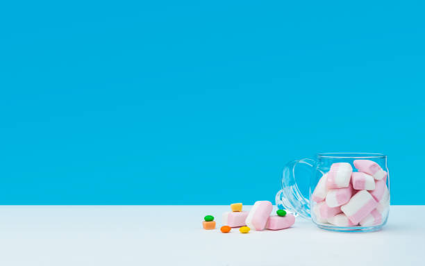 istock Marshmallow with dragee next to the glass open transparent jar and in it 1144357631