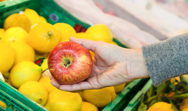 istock Women hand choosing apple at supermarket 1144361423