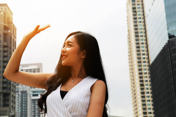 les belles jeunes femmes élèvent protègent la lumière du soleil en tine d’été à bangkok, thaïlande. - tine photos et images de collection