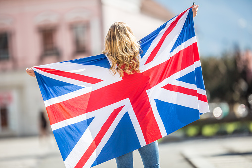 Attractive happy young girl with the flag of the Great Britain.