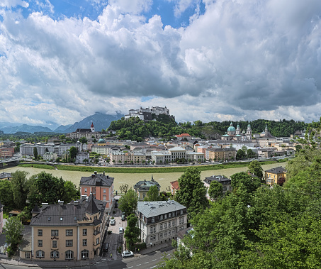 Salzburg Old Town with low cumulus clouds above it, Austria. View from the fortified wall at the Kapuzinerberg mountain.
