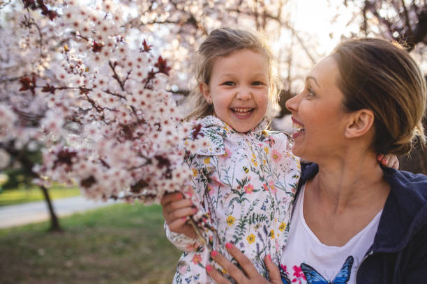 Gorgeous young child enjoying a Spring day at a park with her young mother.