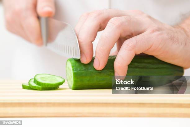 Die Hände Des Mannes Die Grüne Gurke Mit Großem Messer Auf Holzbrett Schneiden Zutaten Für Salat Zubereiten Closeup Frontansicht Stockfoto und mehr Bilder von Abnehmen
