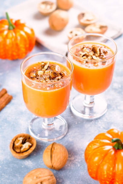istock Healthy pumpkin smoothie with walnuts and cinnamon in glasses on rustic background 1144369813