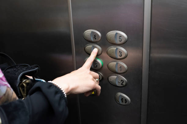istock woman inside an elevator pressing a button of the box 1144370583