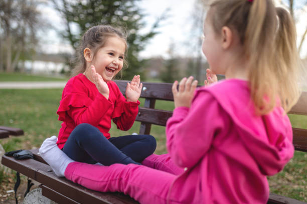 istock Beautiful young sisters playing on a park bench 1144370827