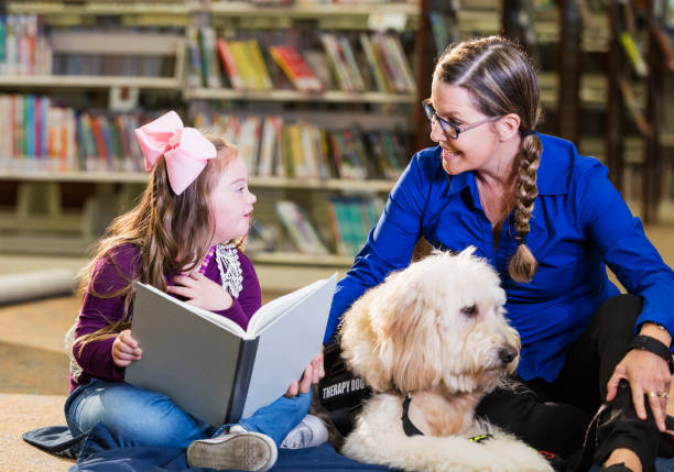 istock Girl with down syndrome in library with therapy dog 1144371888