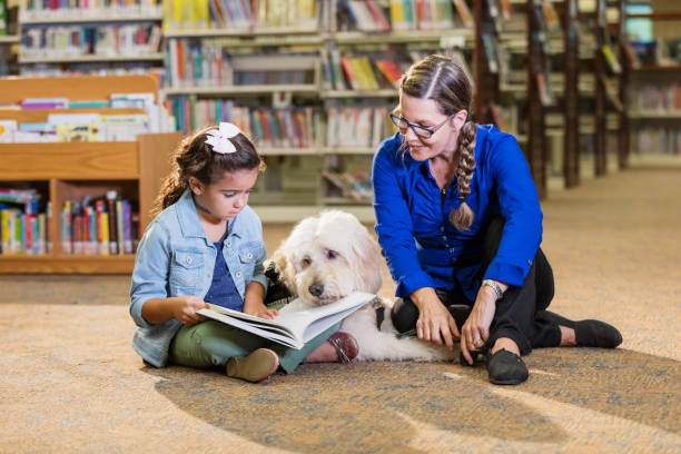 istock Hispanic girl reading in library with therapy dog 1144371889