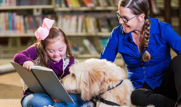 istock Girl with down syndrome in library with therapy dog 1144372049
