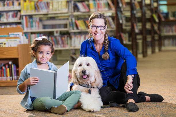 istock Hispanic girl reading in library with therapy dog 1144372050