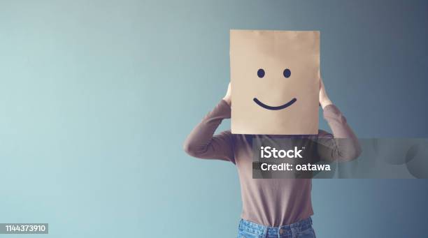 Woman Covering His Face With A Smiling Face Emoticon Copy Space Stock Photo - Download Image Now