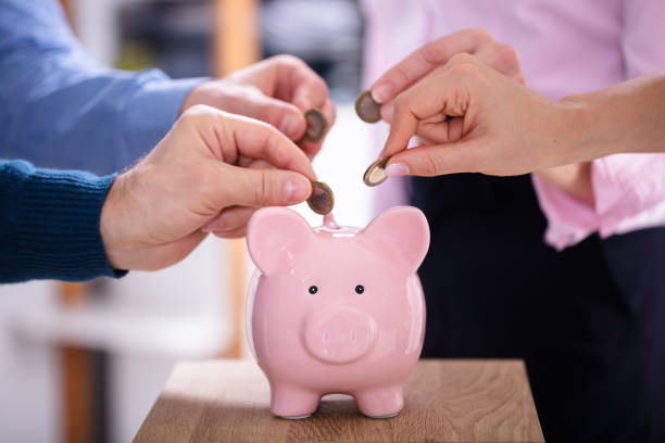 istock People Inserting Coins Into Piggybank 1144374172