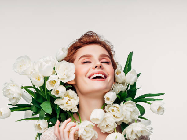 Portrait of a young blonde girl with a bouquet of tulips