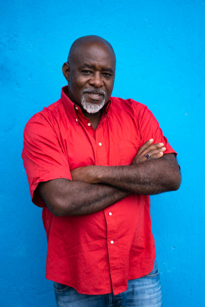 istock Mature man standing in front of blue background and looking at camera 1144375806