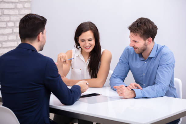 istock Advisor Sitting With Smiling Young Couple 1144377658