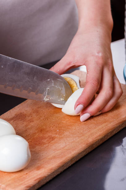 istock young woman in a gray apron cuts a boiled egg 1144378335