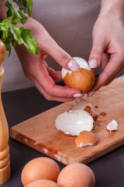istock young woman in a gray apron cleans the boiled egg 1144378342