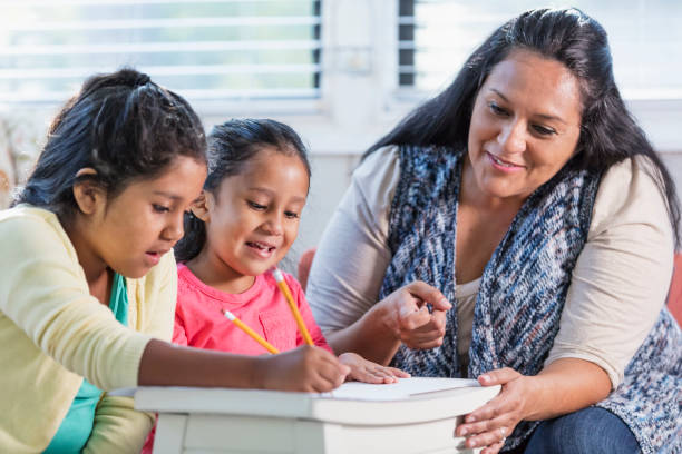 istock Hispanic mother helping girls with homework 1144381299