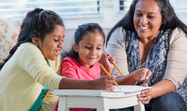 istock Hispanic mother helping girls with homework 1144381337