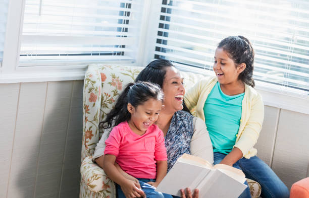 istock Hispanic mother reading to her two daughters 1144381611