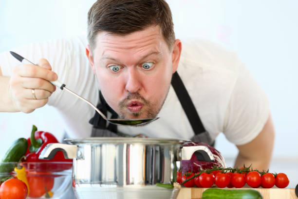 istock Male cook tries hot soup from pan 1144381630