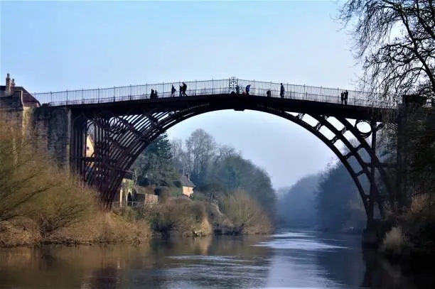 Photo taken upstream of the world famous Ironbridge in Shropshire, England.  Spanning the River Severn, this is it at low river level and on a clear day in its refurbished colour scheme in 2018.