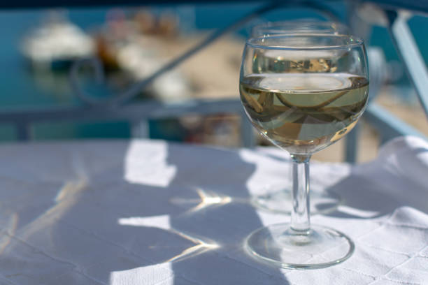 istock White wine served outside on balcony on glass table with sea view 1144384864